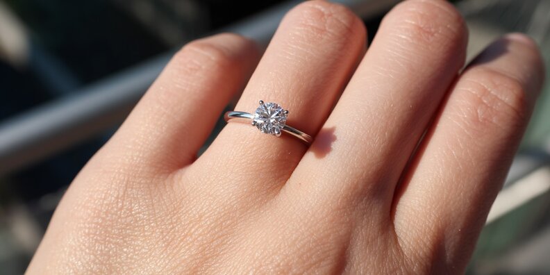 Doğal ışık koşullarında VS pırlanta yüzük takan bir elin fotoğrafı 1